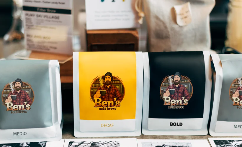 Various bags of coffee beans, each showing the cartoon logo of Ben's Bold Brews in different colors.